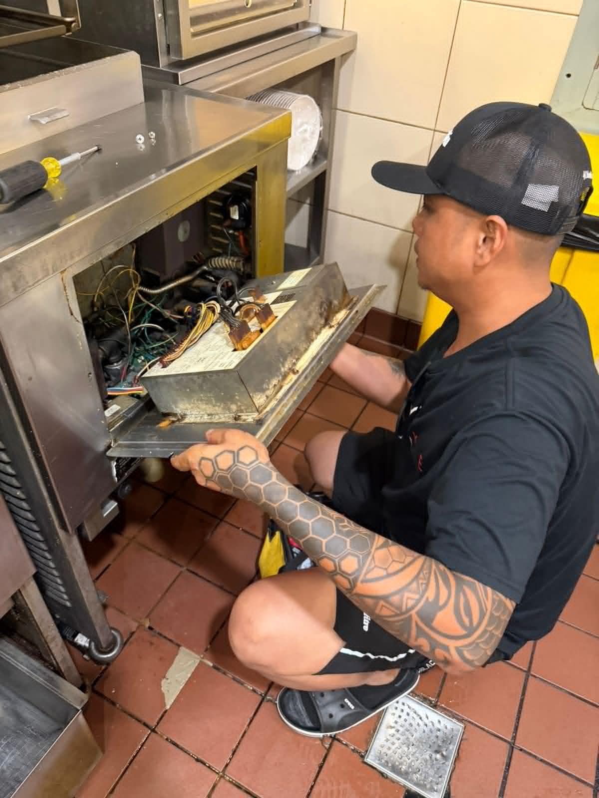 Technician servicing commercial kitchen equipment